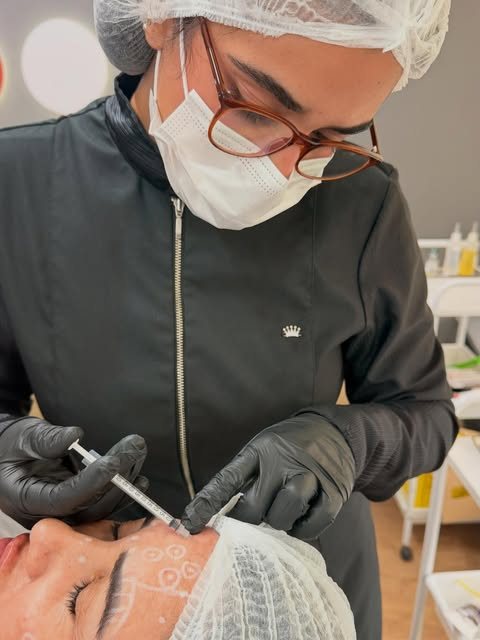 Dra. Beatriz realizando aplicação facial com marcações de planejamento